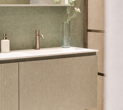 Salle de bains avec un meuble de salle de bains vert sauge, équipé d'une robinetterie en bronze et d'une douche en verre nervuré, ainsi que de profilés couleur bronze, le tout sur un mur vert sauge