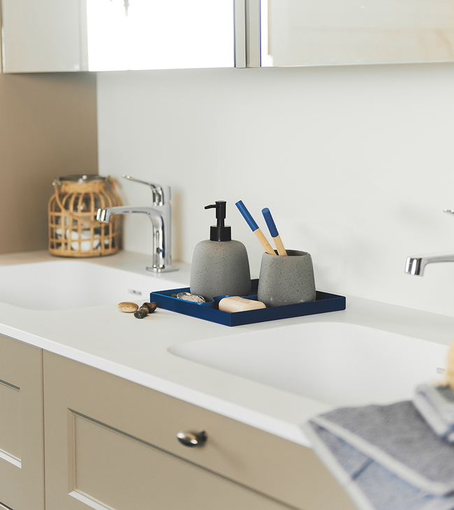 Accessoires de salle de bain bleus sur meuble de salle de bain taupe