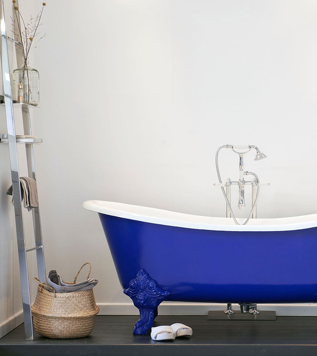 Baignoire traditionnelle bleue sur pieds.
