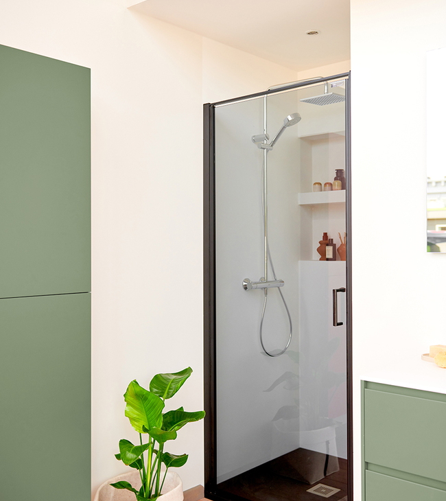 Porte de douche en niche avec verre teinté élégant et cadre noir, associée à des tons naturels doux et une finition moderne.