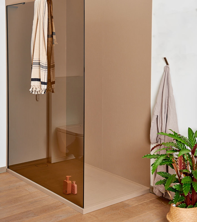 Douche à l’italienne élégante avec panneau mural taupe en acrylique et paroi de douche teintée, installée sur un sol en bois chaleureux.