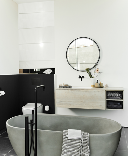 Badkamer in zachte kleuren met vrijstaand bad in betonlook
