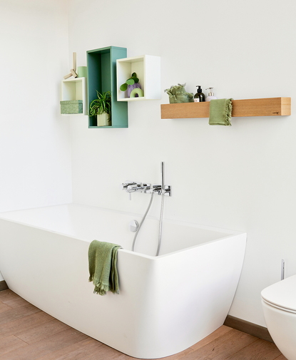 Salle de bain design avec des meubles de salle de bain modernes et épurés, comprenant une étagère flottante en bois et des rangements muraux ouverts ludiques aux couleurs fraîches.