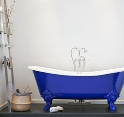 Baignoire traditionnelle bleue sur pieds.